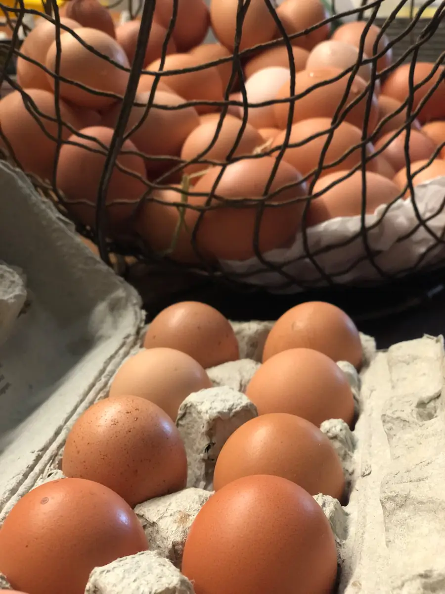 Brown eggs in a wire basket and a carton